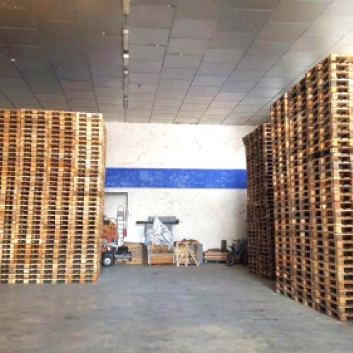 Vista interior de gran nave con palets almacenados a ambos lados